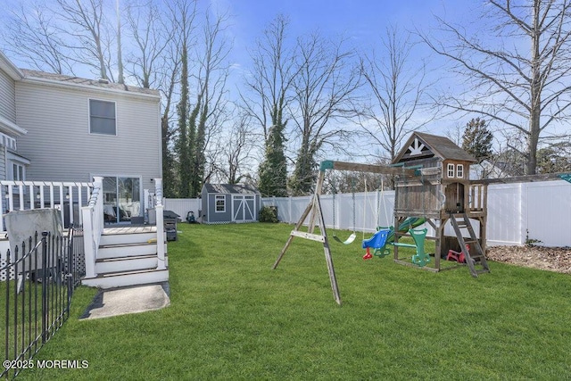 view of yard featuring an outdoor structure, a playground, a storage unit, and a fenced backyard