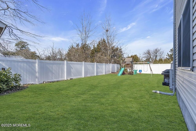 view of yard featuring a fenced backyard and a playground