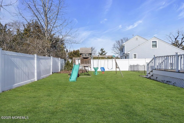 view of yard featuring a playground, a fenced backyard, and a wooden deck