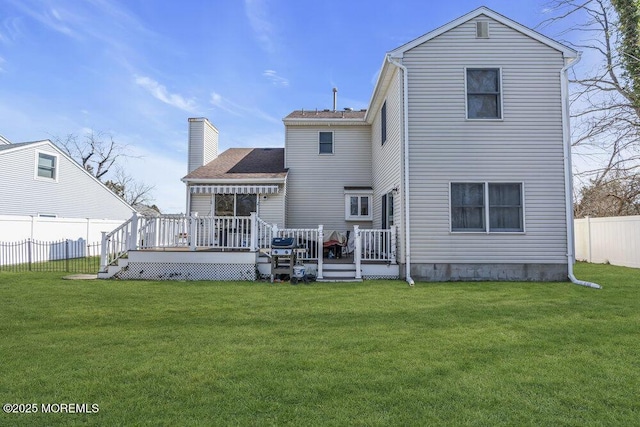 back of house with a chimney, a fenced backyard, a lawn, and a wooden deck