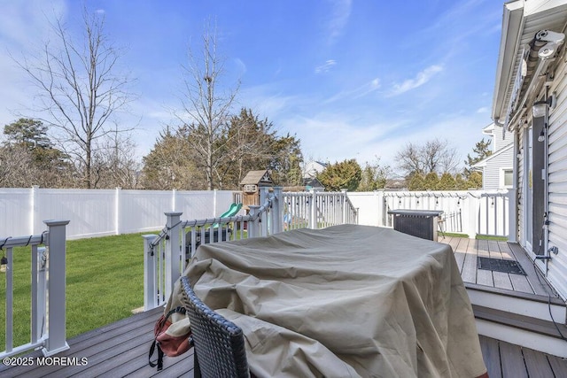 deck featuring a yard, a fenced backyard, and a playground