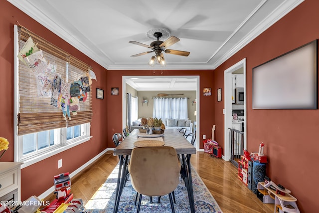 dining area featuring ceiling fan, wood finished floors, baseboards, and ornamental molding