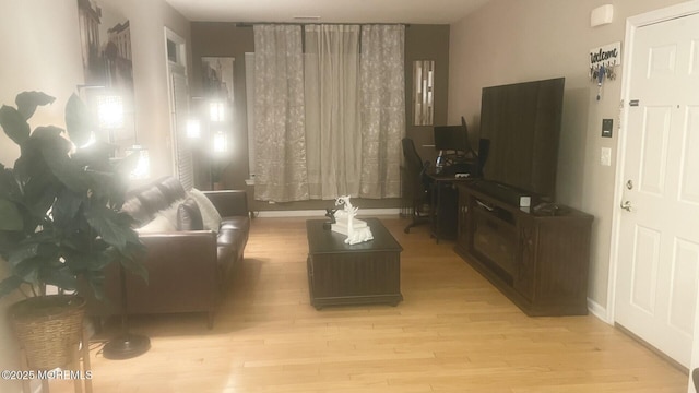 living room with baseboards and wood finished floors