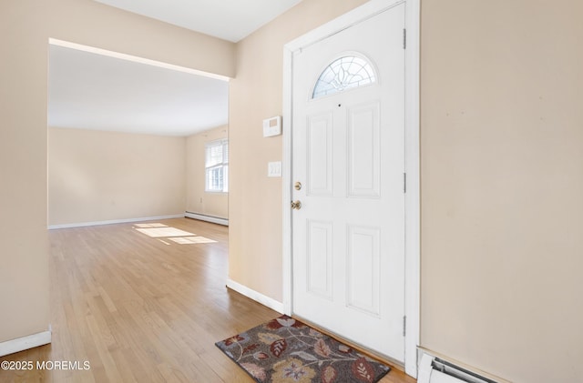 foyer entrance featuring wood finished floors, baseboards, and a baseboard radiator