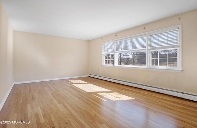 empty room with wood finished floors, baseboards, and baseboard heating