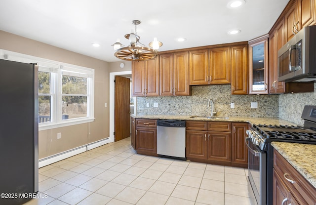 kitchen with light tile patterned flooring, a sink, appliances with stainless steel finishes, and a baseboard radiator