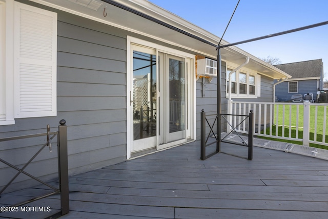 wooden deck featuring a yard and a wall unit AC