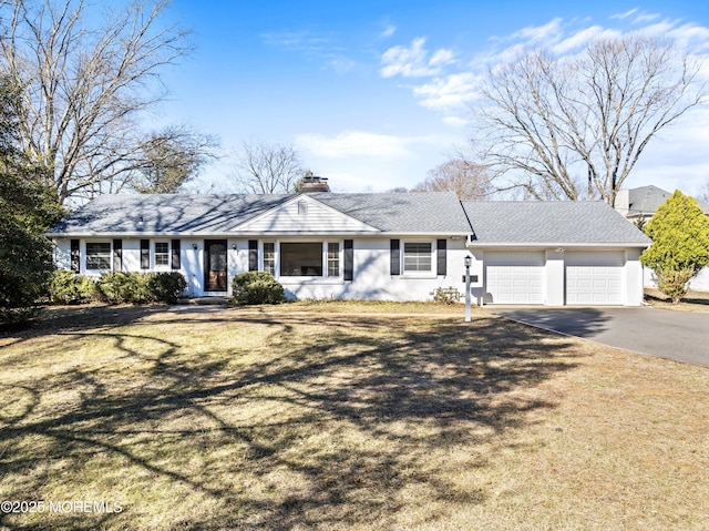 ranch-style home featuring aphalt driveway, a front yard, a garage, and a chimney