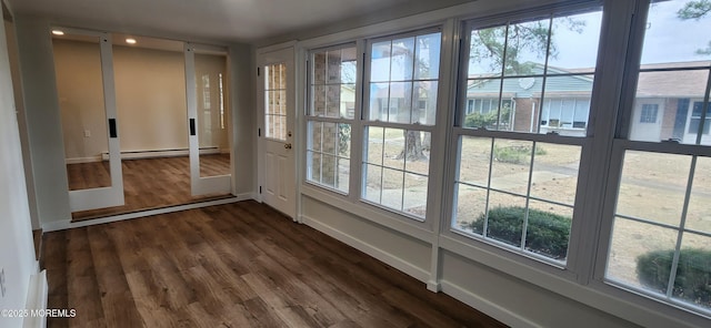 doorway featuring dark wood-type flooring, plenty of natural light, baseboards, and baseboard heating