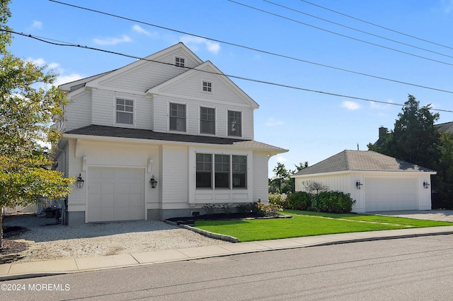 view of front of house with a front lawn, an outbuilding, and a garage