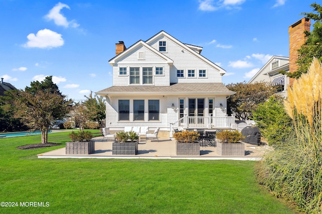 rear view of house with a patio area, a lawn, a chimney, and outdoor lounge area