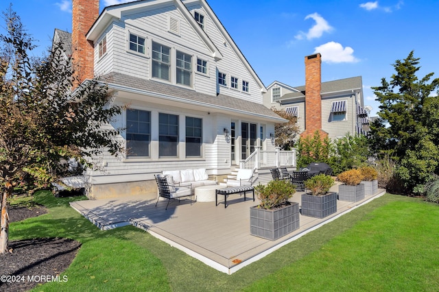 rear view of property featuring an outdoor living space, a patio, a lawn, and a chimney