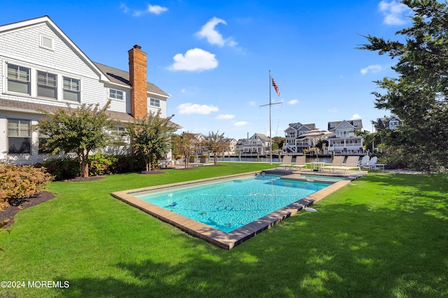 view of pool with a yard and a pool with connected hot tub