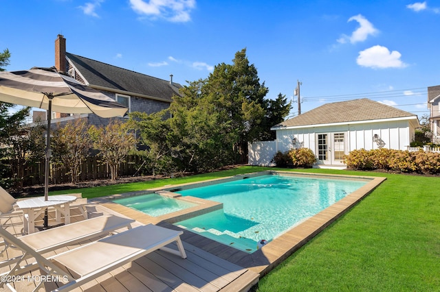 view of swimming pool with a pool with connected hot tub, a wooden deck, a lawn, french doors, and a fenced backyard