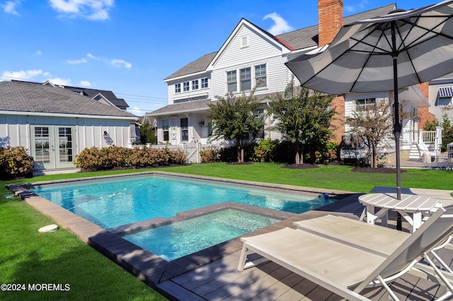 view of pool featuring a yard, french doors, fence, and a pool with connected hot tub