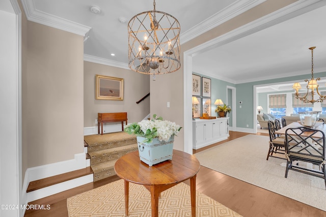 dining area with a chandelier, stairway, crown molding, and wood finished floors