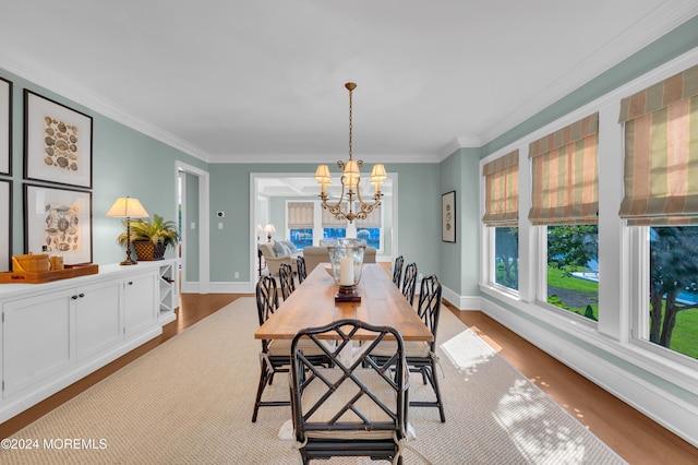 dining area featuring ornamental molding, baseboards, an inviting chandelier, and wood finished floors