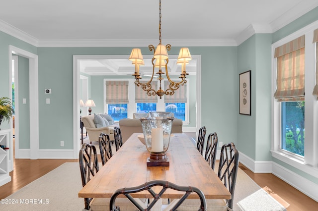 dining space featuring crown molding, a notable chandelier, wood finished floors, and baseboards