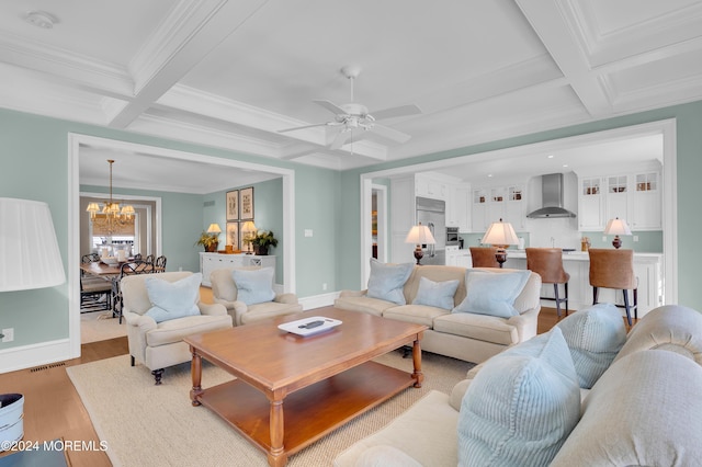 living area featuring visible vents, beam ceiling, coffered ceiling, crown molding, and light wood finished floors