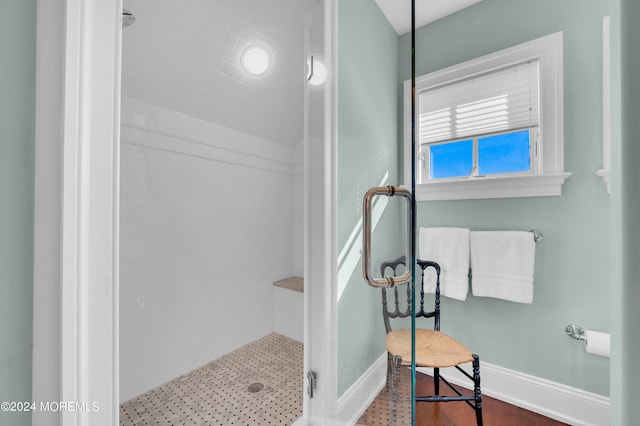 bathroom featuring baseboards and a shower stall