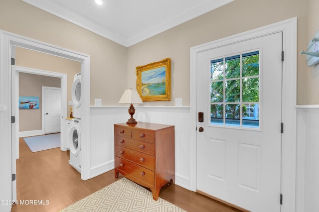 interior space featuring stacked washer / dryer, wood finished floors, and a wainscoted wall