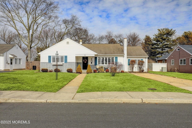 view of front of home with a front yard, fence, and a chimney