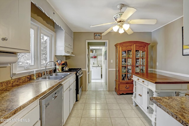 kitchen with light tile patterned floors, washer / dryer, appliances with stainless steel finishes, white cabinetry, and a sink