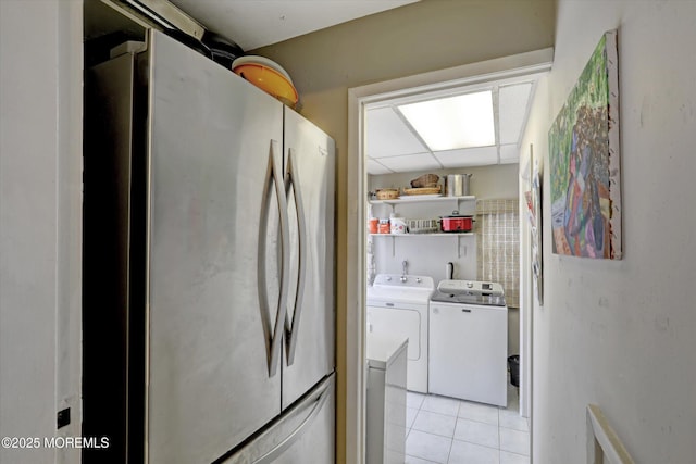 washroom with laundry area, light tile patterned flooring, and separate washer and dryer