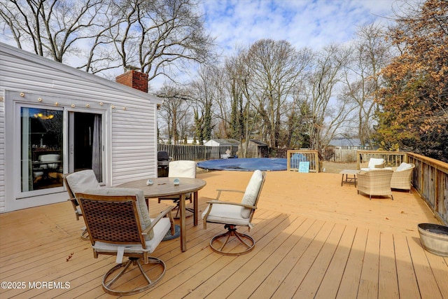 wooden deck featuring outdoor dining space, a fenced backyard, a fenced in pool, and outdoor lounge area