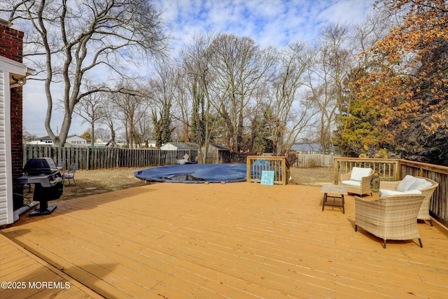 deck with a grill and a fenced backyard