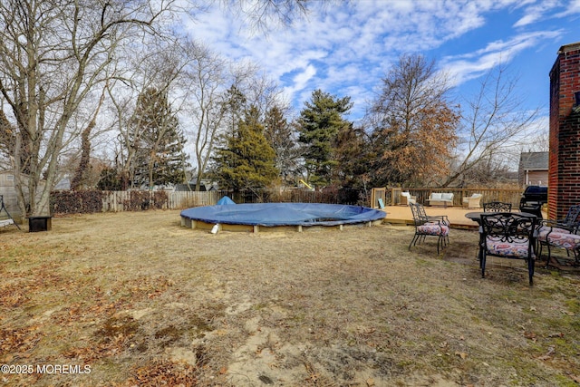 view of yard with a fenced in pool, a fenced backyard, and a trampoline