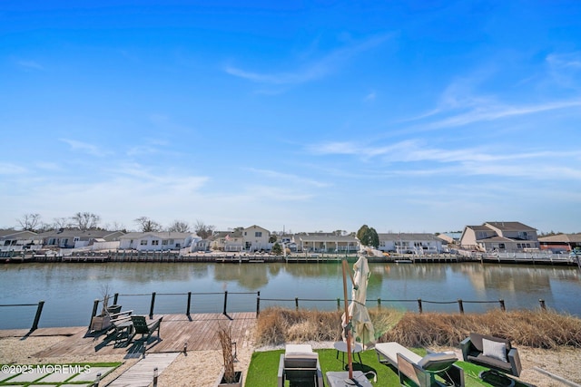 view of water feature featuring a dock, fence, and a residential view