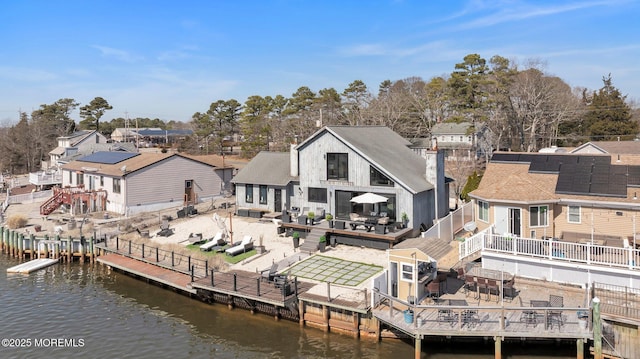 rear view of house featuring a patio area, a residential view, a deck with water view, and a fenced backyard