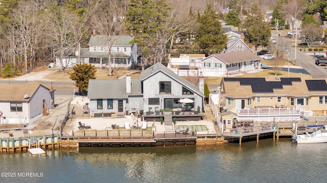 rear view of house with a residential view, fence, and a water view