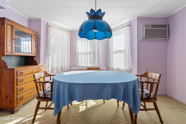 dining room featuring light colored carpet, a wall mounted air conditioner, baseboards, and ornamental molding