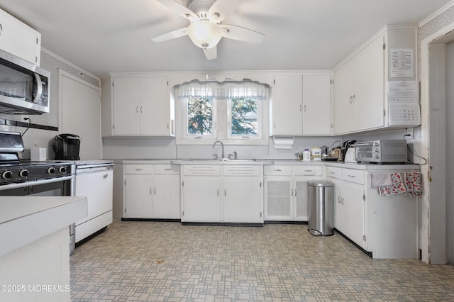 kitchen featuring stainless steel microwave, white cabinets, ceiling fan, and a sink