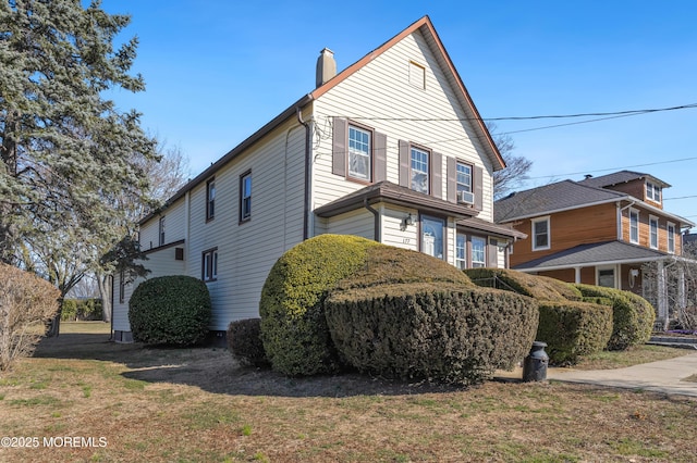 view of home's exterior featuring a lawn and a chimney