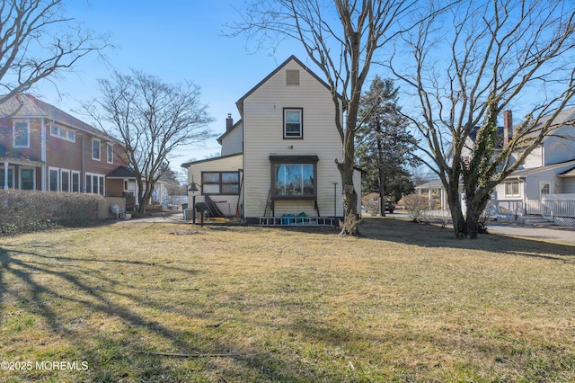 rear view of house with a lawn and a chimney