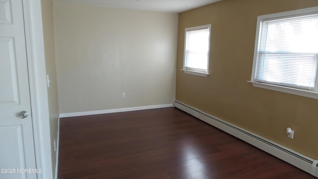 unfurnished room featuring dark wood-type flooring, baseboards, and baseboard heating