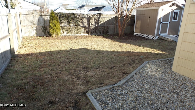 view of yard with a fenced backyard, a storage shed, and an outdoor structure