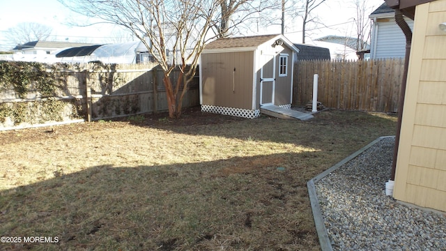 view of yard with an outbuilding, a storage unit, and a fenced backyard