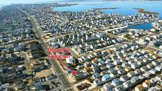 drone / aerial view featuring a residential view and a water view