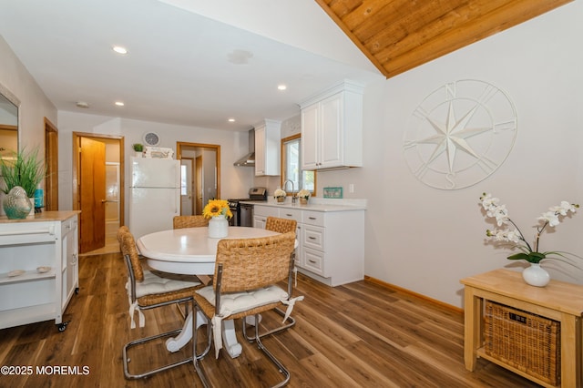 dining area featuring lofted ceiling, recessed lighting, wood finished floors, and baseboards