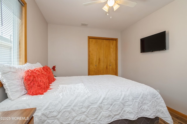 bedroom with baseboards, visible vents, a closet, and ceiling fan