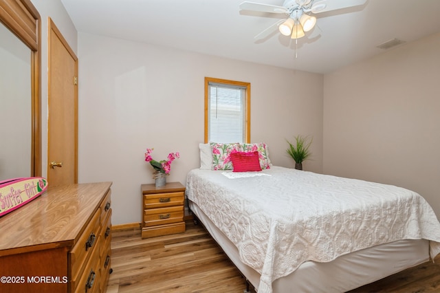 bedroom with ceiling fan, visible vents, light wood-type flooring, and baseboards