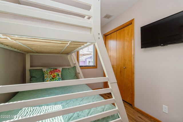 stairs featuring wood finished floors, visible vents, and baseboards