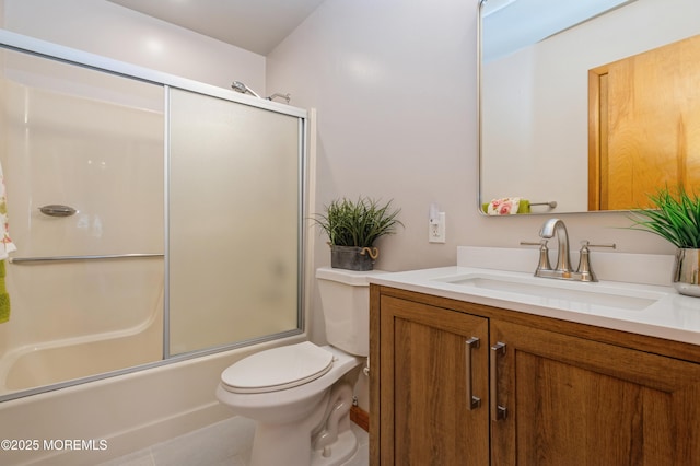 bathroom featuring combined bath / shower with glass door, toilet, and vanity