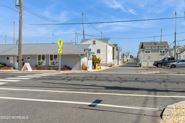 view of road featuring a residential view, curbs, traffic signs, and sidewalks