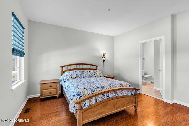 bedroom with visible vents, baseboards, and wood finished floors