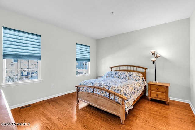 bedroom featuring visible vents, wood finished floors, and baseboards